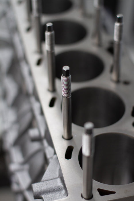 metal engine head stud in engine block with a blurred background of engine head