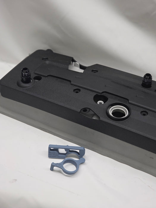 engine rocker cover with plastic cover with black weld on orbs and 3d printed fitting jig with a white background