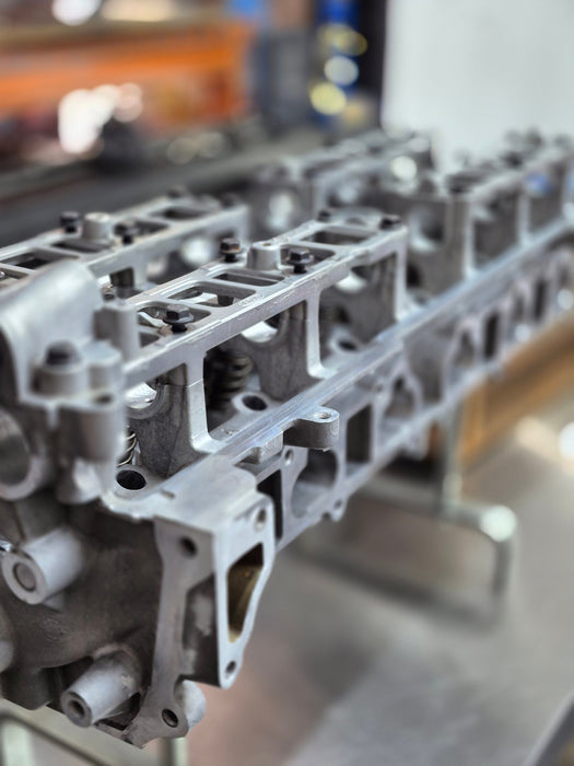 side view of clean engine cylinder head in a workshop setting