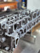 side view of clean engine cylinder head in a workshop setting
