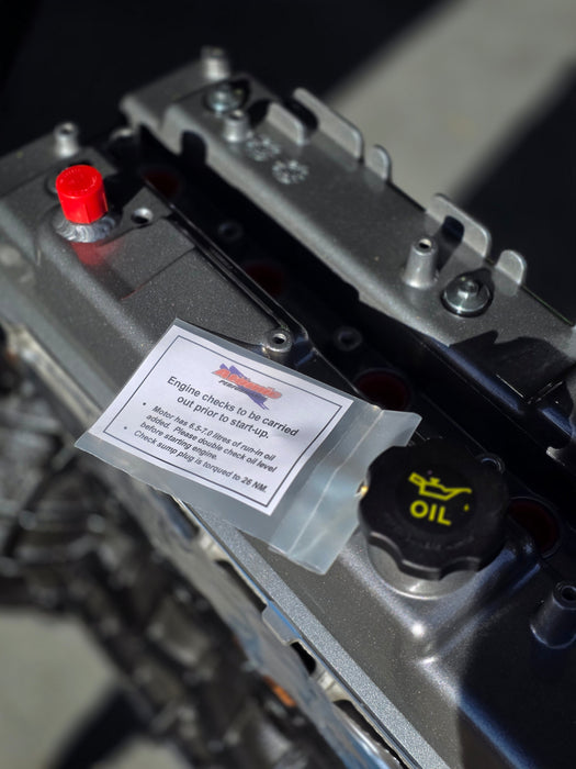 atomic label and tag on grey engine rocker cover with black oil cap and red cap