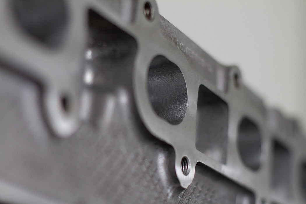 engine cylinder head exhaust port zoomed in with white background
