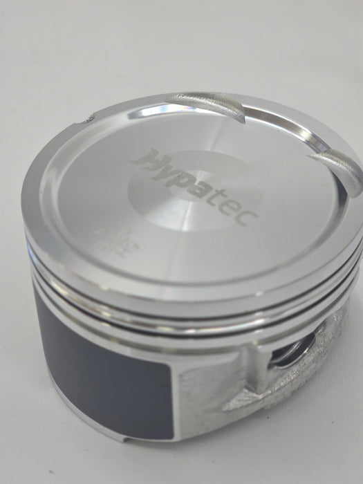 close up of cast engine piston head on white background with engraving